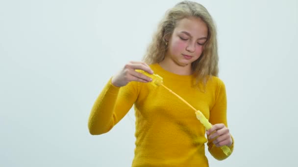 Teenager-Mädchen lässt Seifenblasen aus. weißer Hintergrund — Stockvideo