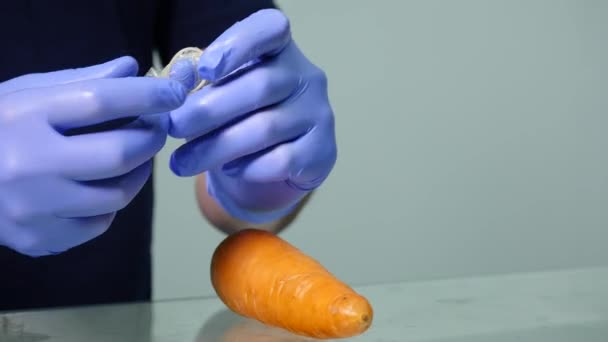 Презерватив и морковь. close up — стоковое видео