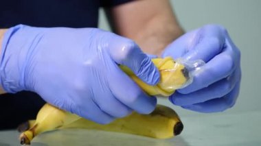 A mans el bir prezervatif bir muz üzerinde koyarak. Güvenli seks ve cinsel yolla bulaşan hastalıklardan korunma