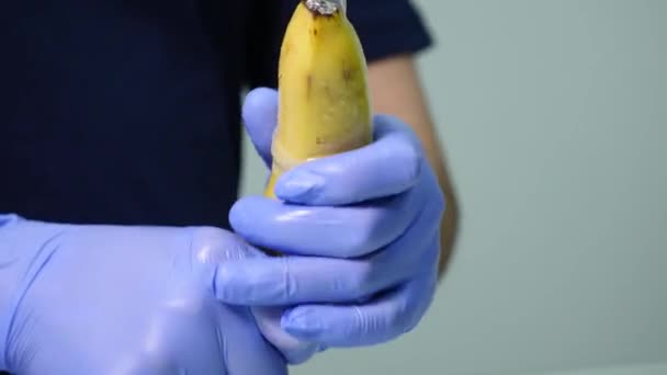 Чоловіча рука надіває презерватив бананом. Концепція безпечного сексу та профілактики захворювань, що передаються статевим шляхом — стокове відео