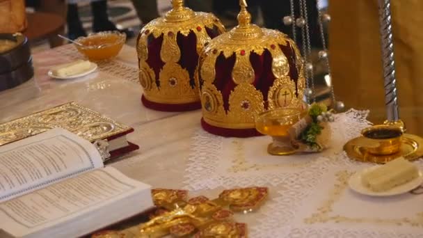 Atributos da igreja para cerimônia de casamento. Coroas de ouro estão no altar. Atributos do padre. Interior da igreja — Vídeo de Stock