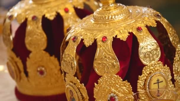 Attributs de l'église pour la cérémonie de mariage. Des couronnes d'or sont sur l'autel. Attributs du prêtre. Intérieur de l'église — Video