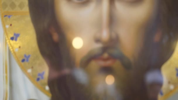 Иисус, пронзительный сквозь свечи, мягкий фокус — стоковое видео