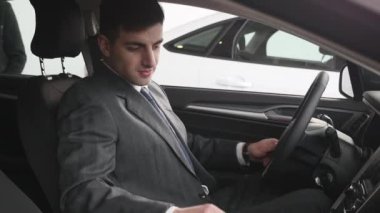 Bir adam iç araç olup olmadığını denetler. Otomatik iş, araba Satılık, teknoloji ve insan kavramı - auto göstermek ya da salon araba satıcısı ile mutlu erkek. Bir satıcı motor gösterisi ile genç adam