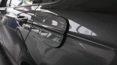 Bir kişi bir araba benzin deposunu açar