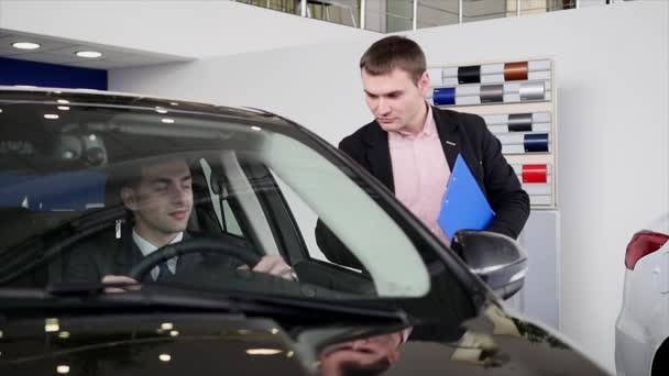Käufer im Gespräch mit Autoverkäufer während der Inspektion des Autos — Stockvideo