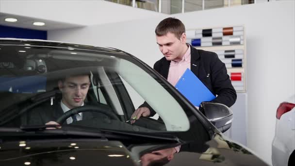 Käufer im Gespräch mit Autoverkäufer während der Inspektion des Autos — Stockvideo