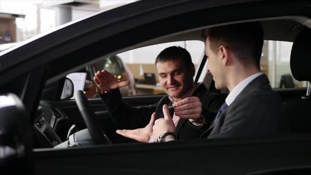 Concesionario de coches da al cliente las llaves del coche en el coche — Vídeo de stock