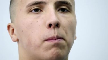 genç adam bir salatalık beyaz bir arka plan üzerinde yeme