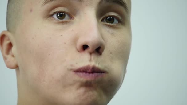 白い背景の上にキュウリを食べる若い男 — ストック動画