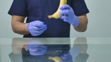 A mans el bir prezervatif bir muz üzerinde koyarak. Güvenli seks ve cinsel yolla bulaşan hastalıklardan korunma