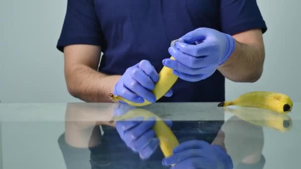 一个男人把避孕套放在香蕉上安全性行为的概念及预防性传播疾病 — 图库视频影像
