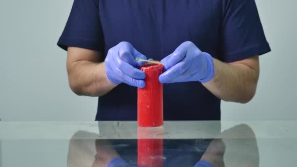 Mani di un uomo che indossa un preservativo su una candela — Video Stock