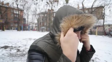 Siyah şapkalı elleri soğuk kış havalarda ısınma bir genç adam portresi. Yakın çekim. Açık havada