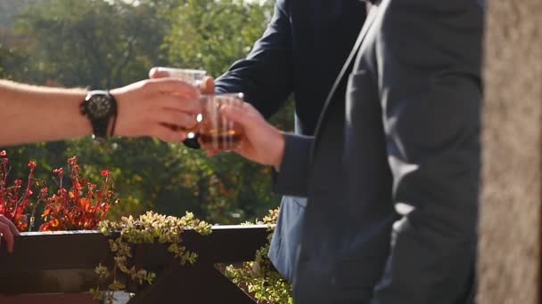 Los hombres beben alcohol en el patio trasero — Vídeos de Stock