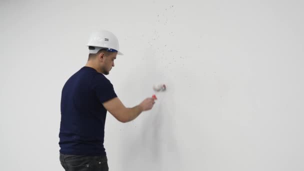 Jongeman schilderen muur tijdens renovatie huis, 4k — Stockvideo