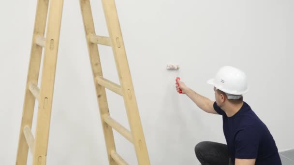 若い男の絵画壁改修ホーム、4 k の中に — ストック動画