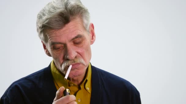 Retrato de un hombre mayor con cigarrillo y pensando en el fondo blanco — Vídeos de Stock