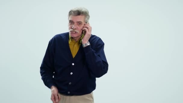 Rozzlobený starší muž mluvit na mobilním telefonu — Stock video