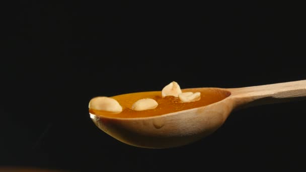 Honey and nuts on wooden spoon close up — Stock Video