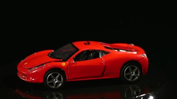 Springendes Spielzeugauto auf fahrendem Subwoofer auf schwarzem Hintergrund — Stockvideo