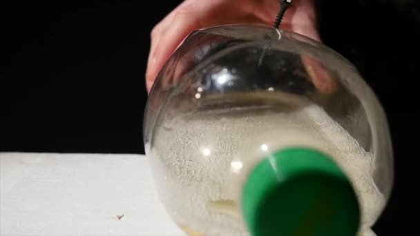 The man twists the screws into the bottle using a screwdriver. — Stock Video
