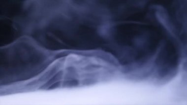 Siyah arkaplan karşısında uzayda süzülen duman