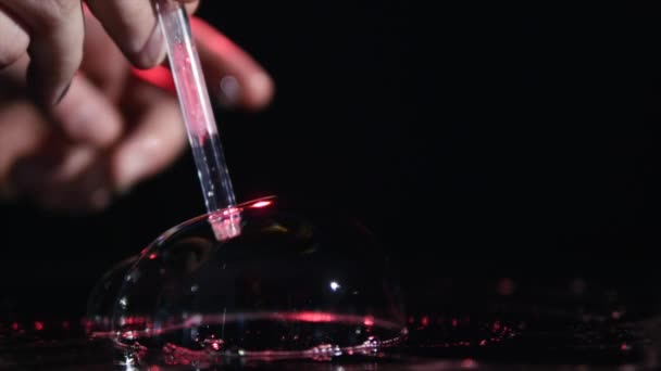 Close-up van rode zeepbellen op zwarte achtergrond — Stockvideo