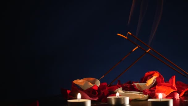 Räucherstäbchen und Kerzen brennen und Rauch auf dunklem Grund, Rauch von Weihrauch und Kerzenschein — Stockvideo