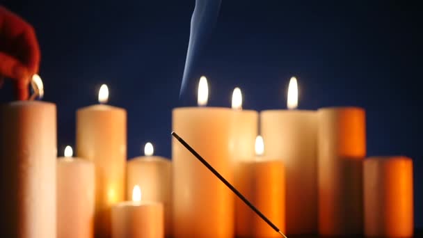 Infiammazione del bastone aroma sullo sfondo di candele infiammate — Video Stock