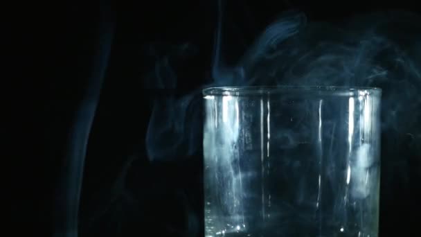 Fumée dans le verre sur fond noir 