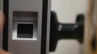 Adam kapıyı girmek için tasarlanmış bir parmak izi tarayıcı parmağını koyar. Modern güvenlik teknoloji çalışanların günlük hayatımızda. Hırsızlık karşı koruma çalışmalarını yakın çekim.