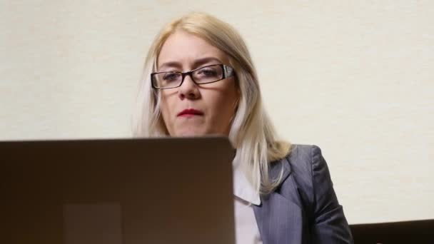 Zakenvrouw eten lunch en werken op de laptop in het café — Stockvideo