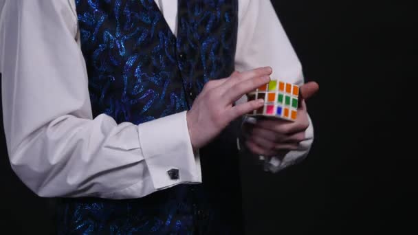 As mãos de um mágico mostram-nos o cubo de Rubiks desmontado, depois fazem um passe mágico, e o cubo transforma-se numa fração de segundo num cubo totalmente montado. — Vídeo de Stock