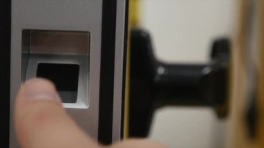 Adam kapıyı girmek için tasarlanmış bir parmak izi tarayıcı parmağını koyar. Modern güvenlik teknoloji çalışanların günlük hayatımızda. Hırsızlık karşı koruma çalışmalarını yakın çekim.