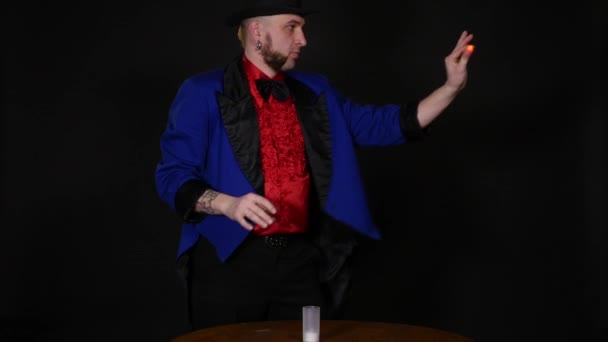 The magician shows tricks on black background — Stock Video