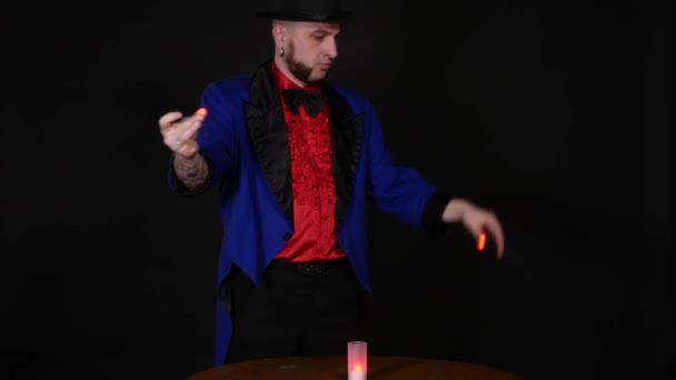 De goochelaar toont trucs op zwarte achtergrond — Stockvideo