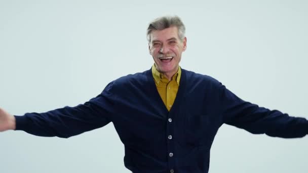 Porträt eines älteren Mannes, der auf weißem Hintergrund lacht — Stockvideo