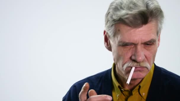 Portrait of a senior man with a cigarette and talking on white background — Stock Video