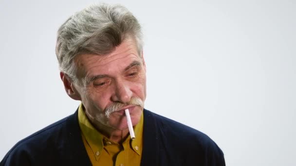 Portrait d'un homme âgé avec cigarette et pensée sur fond blanc — Video