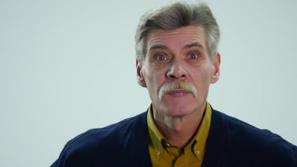 Старший чоловік демонструє різні емоції під час розмови — стокове відео