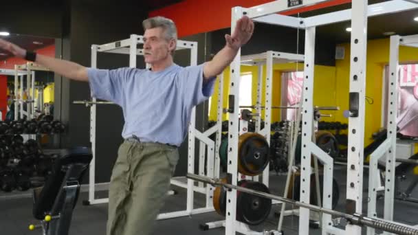 Spor salonunda egzersiz yapan yaşlı bir adam. — Stok video