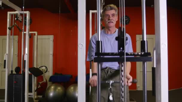 Äldre man med hjälp av tränare i gymmet — Stockvideo