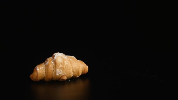 Karamel wordt gegoten op croissant op zwarte achtergrond — Stockvideo