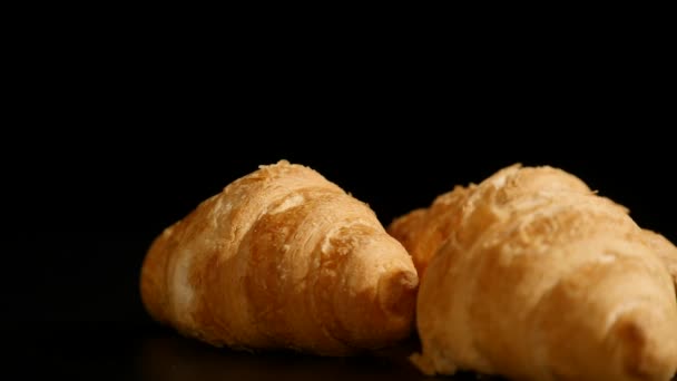 Tři croissanty točit na černém pozadí — Stock video