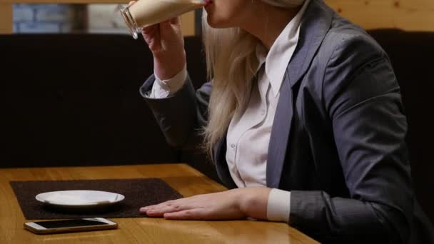 Vrouw die koffie drinkt in cafe — Stockvideo