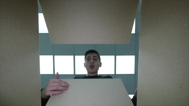 Людина відкриває коробку Посміхаючись розтягуючи руки всередині корпусу, так щасливий і усміхнений — стокове відео