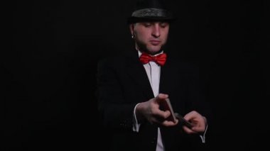 Genç büyücü sihirli oyun kağıdı hüner gösterisi konsept numara siyah arka plan üzerinde gösterir.