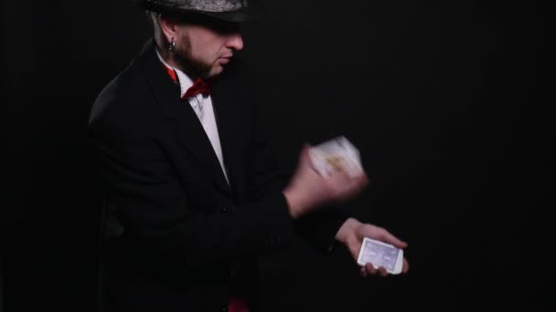 Jovem mágico mostra magia jogando truque de cartas mostrar truque conceito no fundo preto — Vídeo de Stock