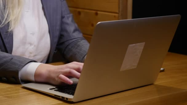 Mujer joven que trabaja en el ordenador portátil moderno en la cafetería — Vídeos de Stock